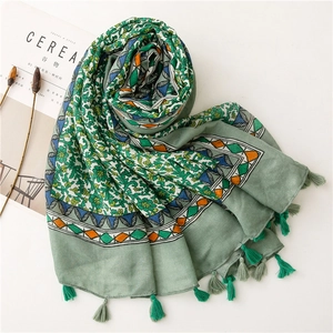 Detail of grey-green floral cotton scarf with tassel trim and geometric patterns