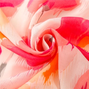 Detailed macro view of the woven linen texture and vibrant floral pattern on the scarf