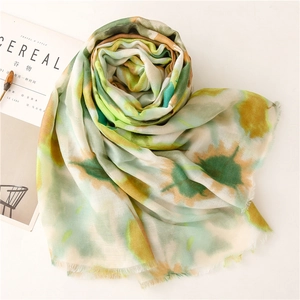 Detailed view of lightweight sunflower print scarf with delicate frayed edges on white surface