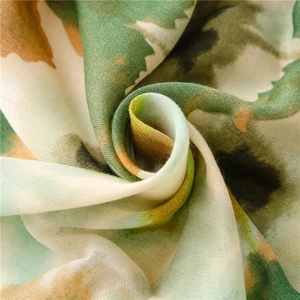 Macro detail of soft floral scarf with abstract green and yellow pattern and fine texture
