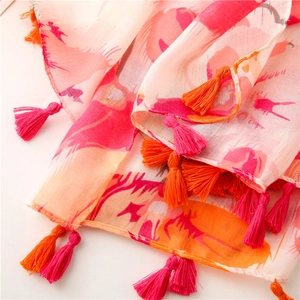 Close-up of lightweight floral scarf showing pink tassel fringe and woven texture