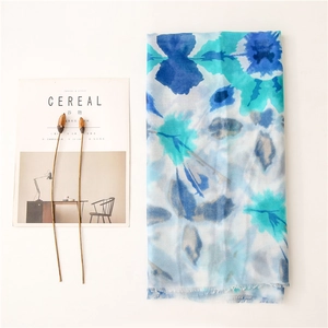 Close-up of lightweight floral scarf with watercolor print and soft frayed edges