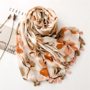 Bohemian floral scarf with orange and beige patterns and colorful tassel edges