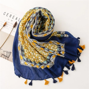 Dark blue linen scarf with yellow vintage patterns and decorative tassels for beach resort
