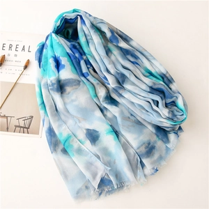 Detail of colorful watercolor pashmina with soft fringe edges and light fabric texture