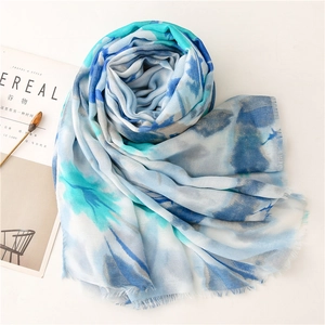Detailed close-up of blue tie-dye scarf with frayed edges on a minimalist white table