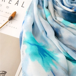 Detail shot of light blue watercolor print scarf with soft fringe and pleated texture