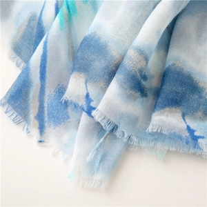 Detail of blue watercolor print scarf with soft fringe edges and lightweight texture