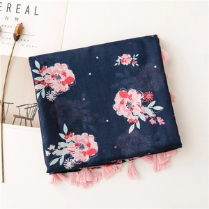 Detail of floral cotton linen scarf with deep blue print and pink fringe tassels