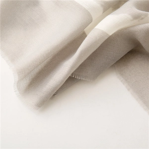 Detail of grey and beige striped cotton linen scarf with fine frayed tassel edges