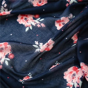 Macro texture of floral cotton-linen fabric with pink flowers on navy blue background