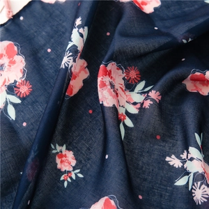 Macro detail of navy blue cotton linen scarf featuring pink floral prints and polka dots