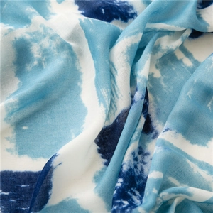Close-up of blue and white abstract tie-dye cotton linen scarf fabric texture