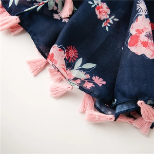 Close-up of floral scarf with pink flower prints and matching pink tassel fringe detail