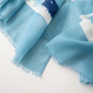 Detail of light blue abstract print cotton linen scarf with natural frayed edges