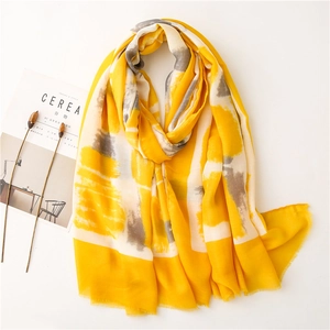Flat lay of yellow linen shawl with abstract geometric patterns and fringe edges