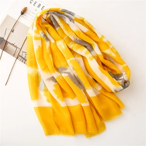 Detail of a bright yellow and grey striped cotton linen shawl with delicate fringe edges