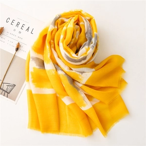 Macro shot of lightweight yellow cotton scarf with abstract gray brushstroke patterns