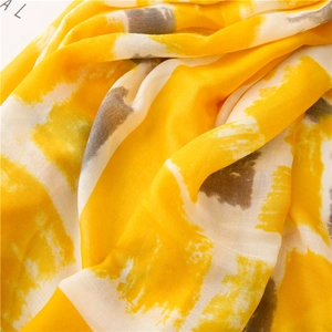 Detailed texture of cotton linen scarf with abstract yellow and grey geometric prints