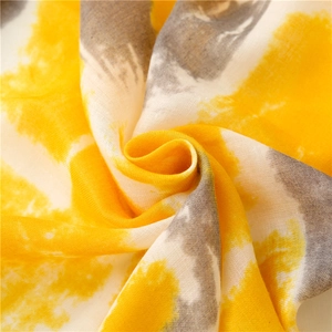 Detail of yellow and grey tie-dye cotton linen scarf with soft woven fabric texture