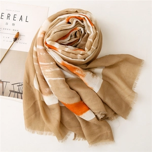 Detailed texture of cotton linen scarf with orange stripes and delicate fringe edges