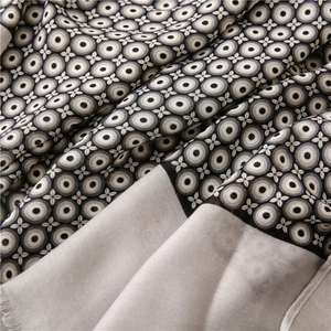 Close-up of lightweight cotton linen scarf showing gray dot patterns and fringe detail