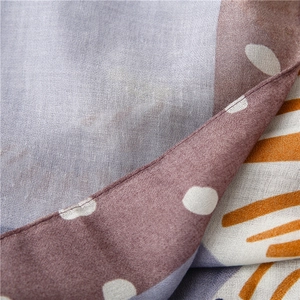 Detailed macro view of linen-cotton scarf featuring abstract zebra print and vivid patterns