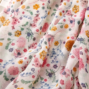 Floral print voile scarf with light pink blossoms and fringe detail for summer beach use