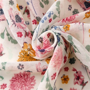Close-up of lightweight floral scarf fabric showing slub texture and vibrant petal print
