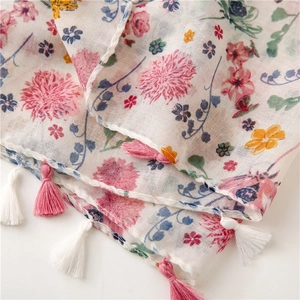 Detailed view of lightweight floral voile scarf with delicate pink and white tassel fringe