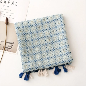Macro detail of geometric floral cotton linen scarf with handmade tassel edge decoration