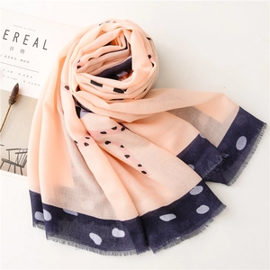 Detail of pink cotton linen scarf with blue polka dots and soft frayed edges