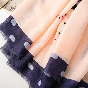 Close-up of peach cotton linen scarf with navy blue borders and white polka dots fringe