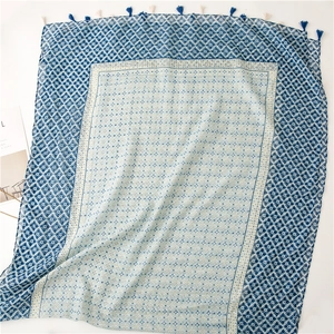 Close-up of geometric pattern and handmade tassel fringe on blue bohemian cotton scarf