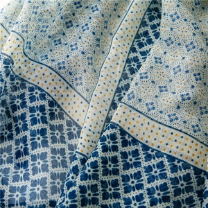 Detailed close-up of navy blue and white floral scarf with orange polka dots