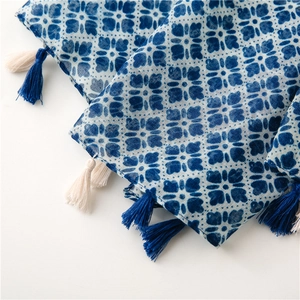 Detail of blue geometric floral print on cotton linen scarf with soft fringe edges