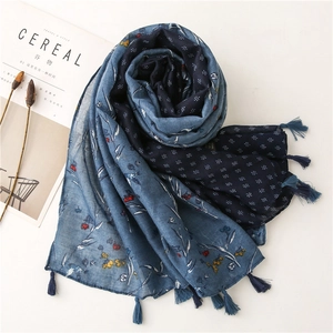 Close-up of blue floral cotton linen scarf with navy polka dots and fringe details