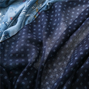 Detailed macro view of retro floral and geometric patterns on soft linen scarf fabric