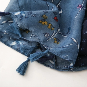 Detail of vintage blue floral linen scarf with intricate fringe edge and woven texture