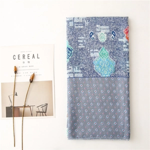 Detail of soft paisley print scarf with geometric patterns and fringe edges on white background