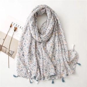 Detail of floral cotton linen scarf with soft fringe tassels and pastel flower pattern