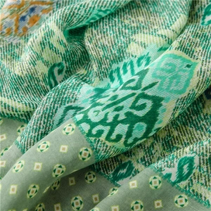 Macro shot of ethnic paisley print on soft green cotton-linen blend fabric texture