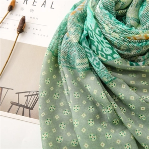 Detail view of green paisley pattern scarf with soft cotton-linen texture for women