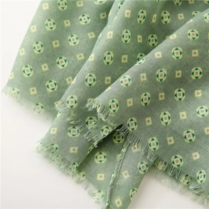 Detail of light green paisley scarf showing soft breathable fabric texture and fringe trim
