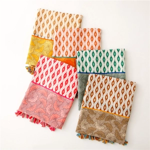 Detail of colorful geometric floral scarves with tassels on soft cotton-linen fabric