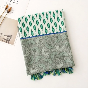 Detailed view of floral geometric scarf with tassel fringe and soft linen texture