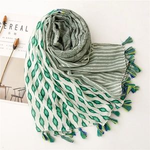 Detailed flat lay of a floral geometric cotton scarf with multicolored tassels and tassels