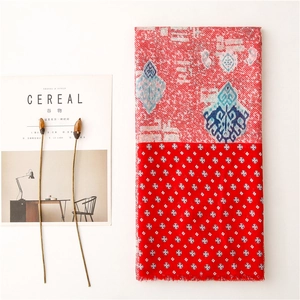 Detail of red paisley cotton scarf with tassel fringe and geometric floral patterns