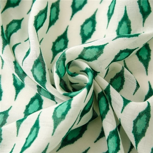 Detail of soft cotton-linen scarf with vintage green geometric ikat floral pattern