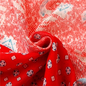 Macro detail of paisley pattern cotton scarf showing red and blue geometric print texture